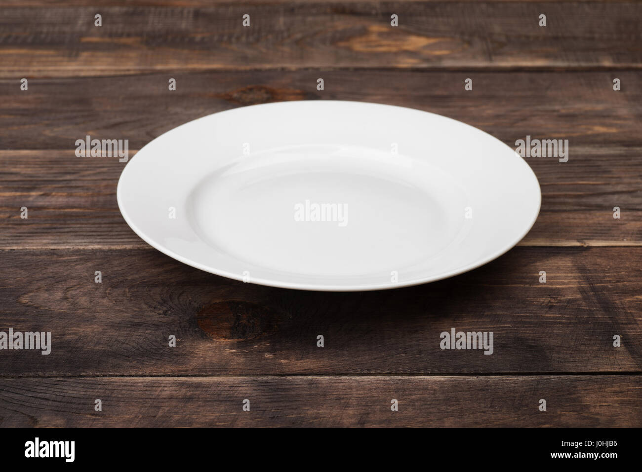 Weißen leeren Teller auf Holztisch ristic Stockfoto