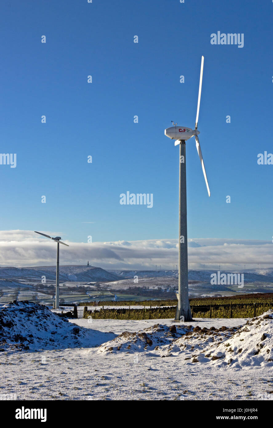 Windkraftanlagen auf Pennine Hills über Hebden Bridge, im Winter mit Stoodley Hecht am Horizont. Stockfoto