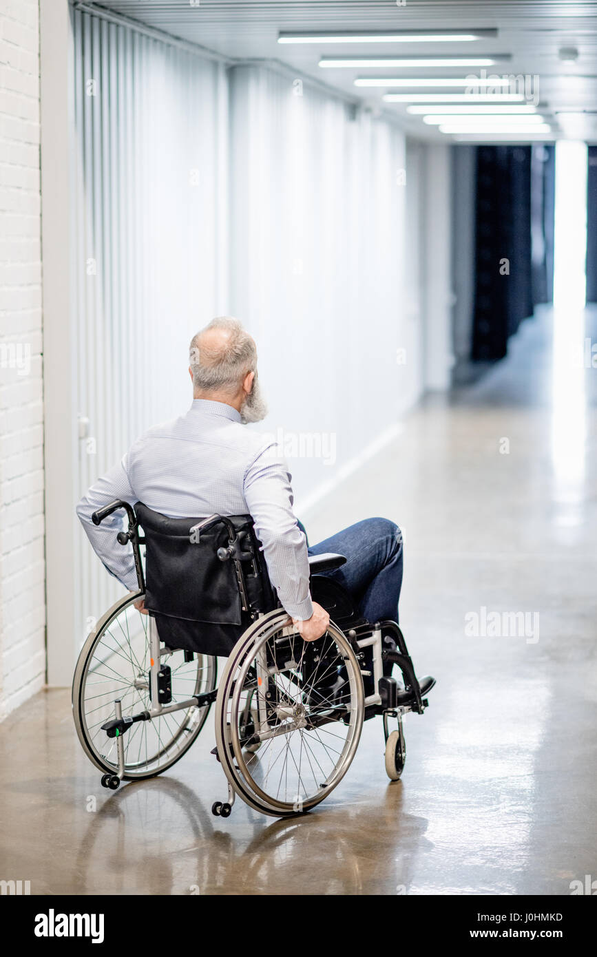 Rückansicht des bärtigen senior Mann im Rollstuhl am Krankenhaus Flur Stockfoto