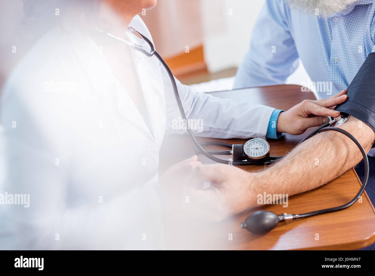 Ärztin, Messdruck senior männlichen Patienten im Krankenhaus Stockfoto