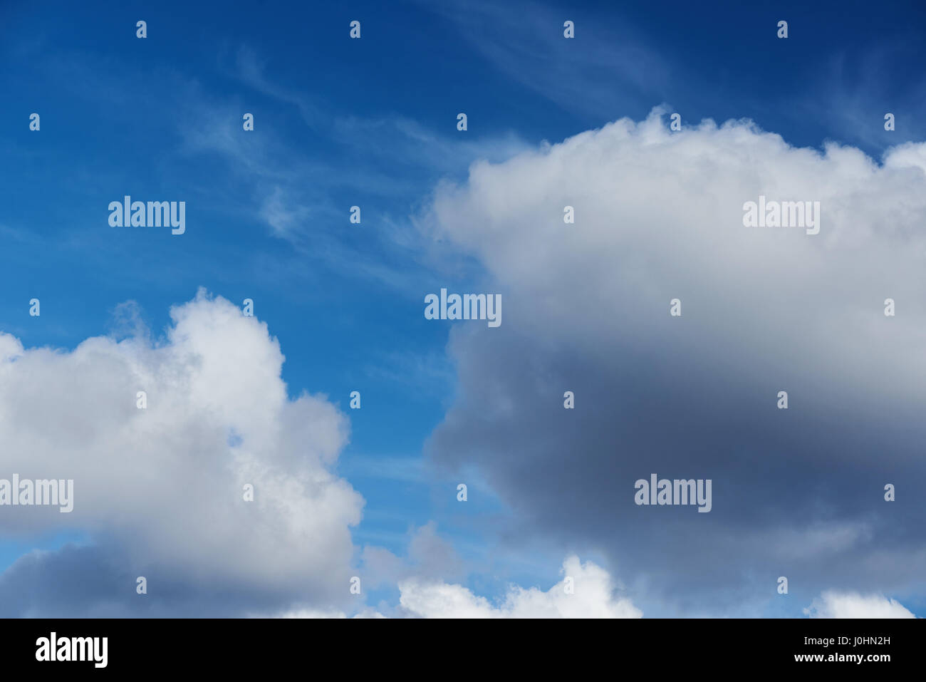 Große Wolken am blauen Himmelshintergrund. Nahaufnahme von Wolkengebilde am sonnigen Tageszeit Stockfoto