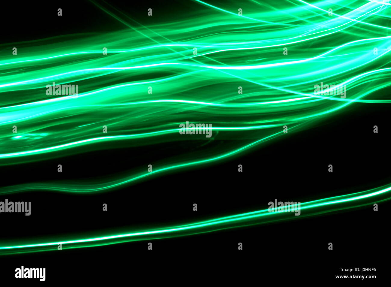 Grünes Licht Malerei Fotografie, lange Belichtung Foto von Neon Grün bunte Wellen auf einem schwarzen Hintergrund. Abstrakte Licht Bewegung. Stockfoto