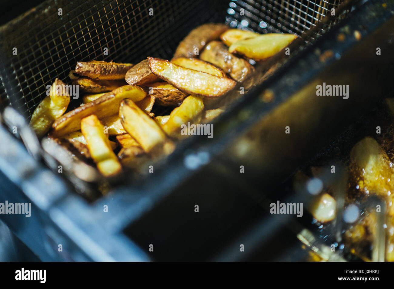 Teil von Hand geschnitten Kartoffel-Chips in einer Pfanne erhitzen Stockfoto