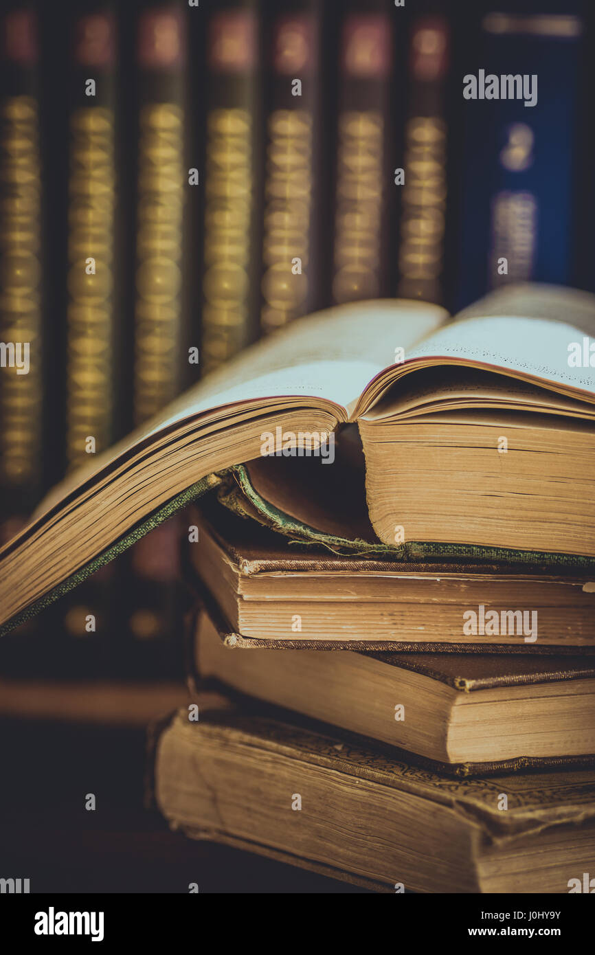 Haufen von gebrauchte alte geöffnete Bücher, Bände mit beeindruckt Cover im Hintergrund, Universitätsausbildung, Lesung Konzept, getönt Stockfoto