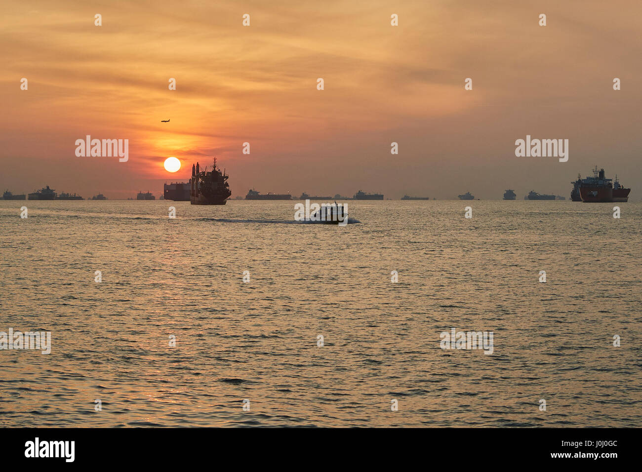 Sonnenaufgang über dem Cargo-Schiffe vor Anker In der Straße von Singapur. Stockfoto