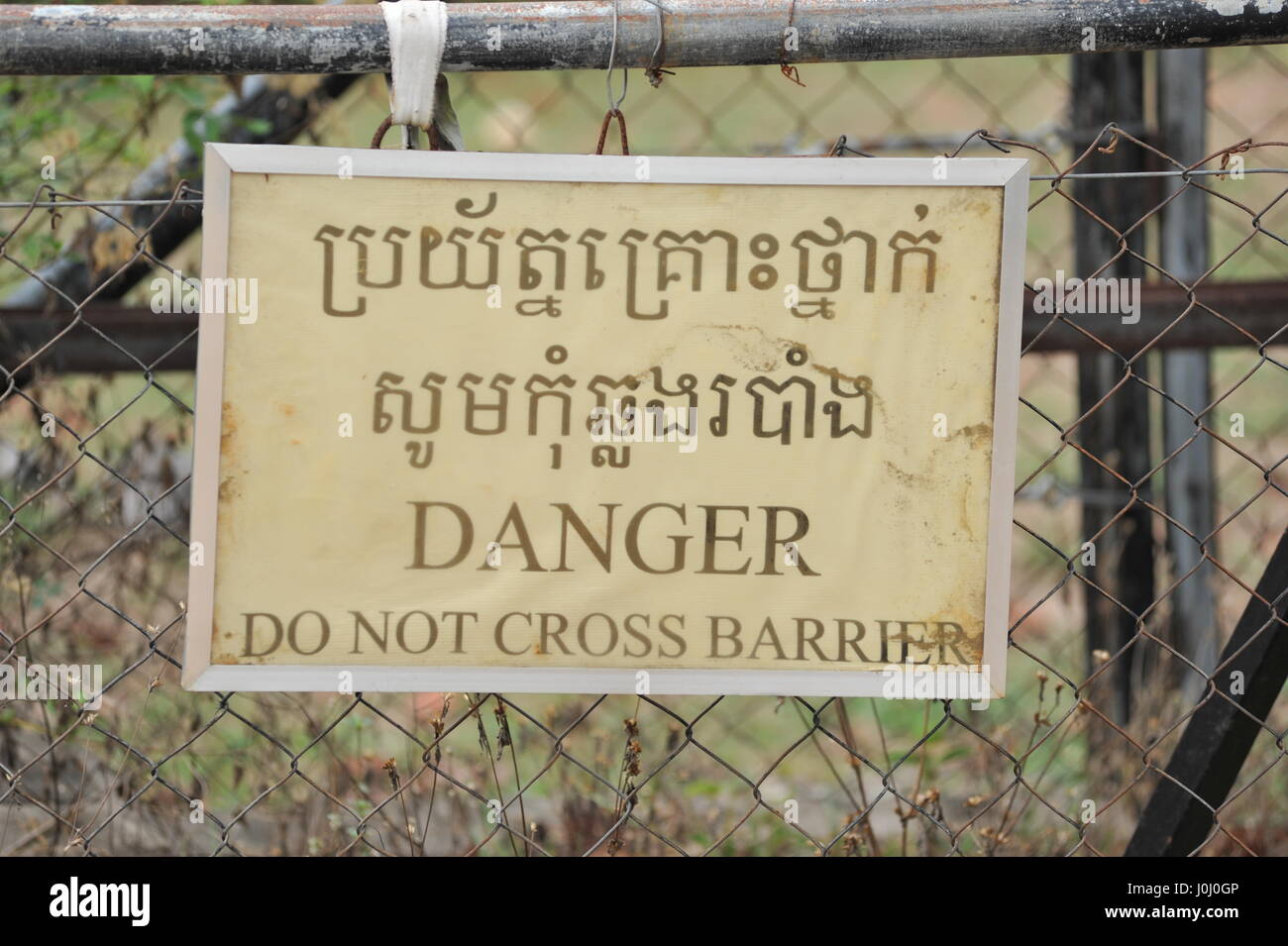 alten verwitterten zweisprachige "DANGER" Schild Phnom Tamao Wildlife Rescue Center, Takeo Province, Kambodscha. Kredit: Kraig Lieb Stockfoto