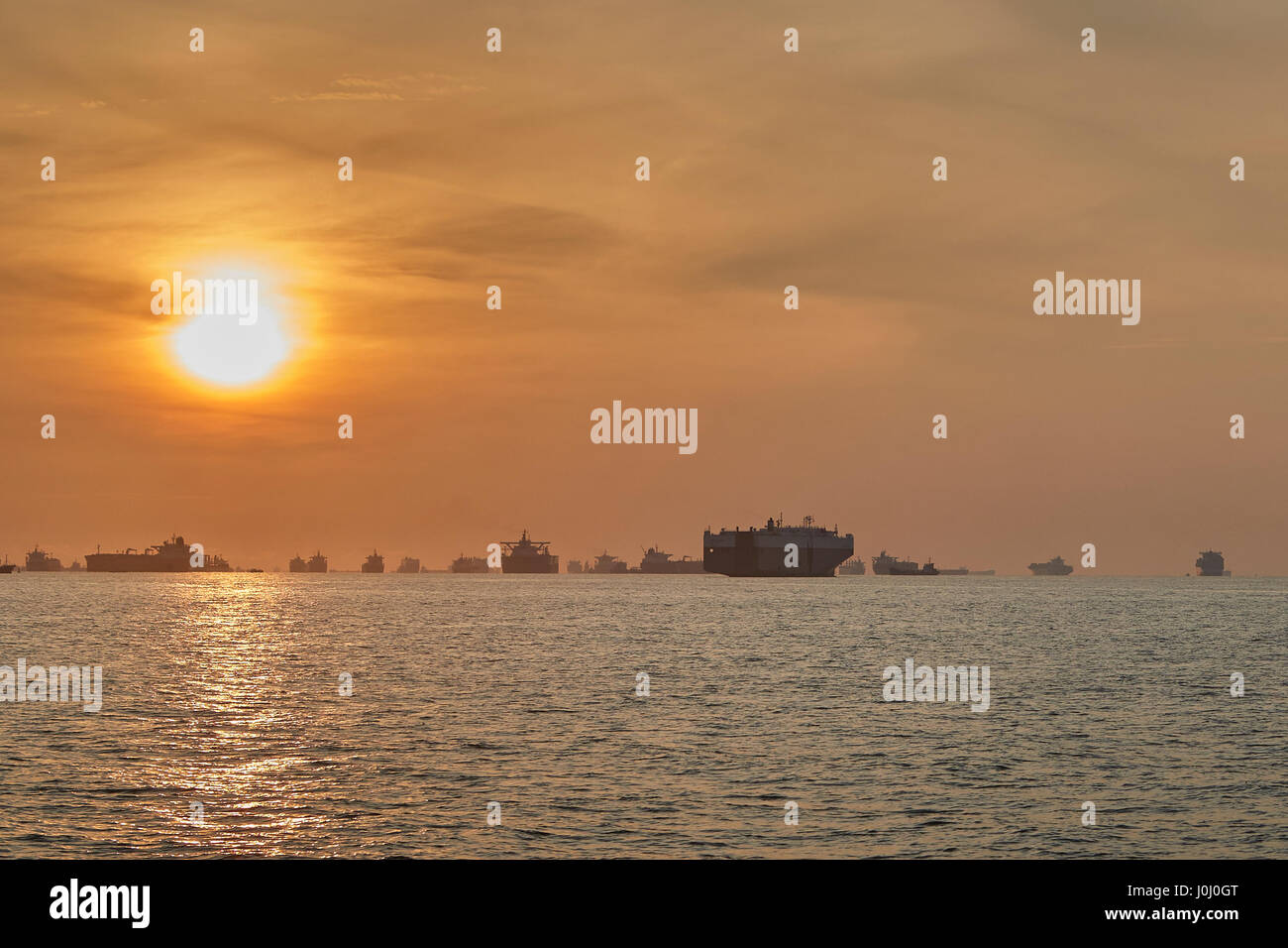 Sonnenaufgang über dem Cargo-Schiffe vor Anker In der Straße von Singapur. Stockfoto