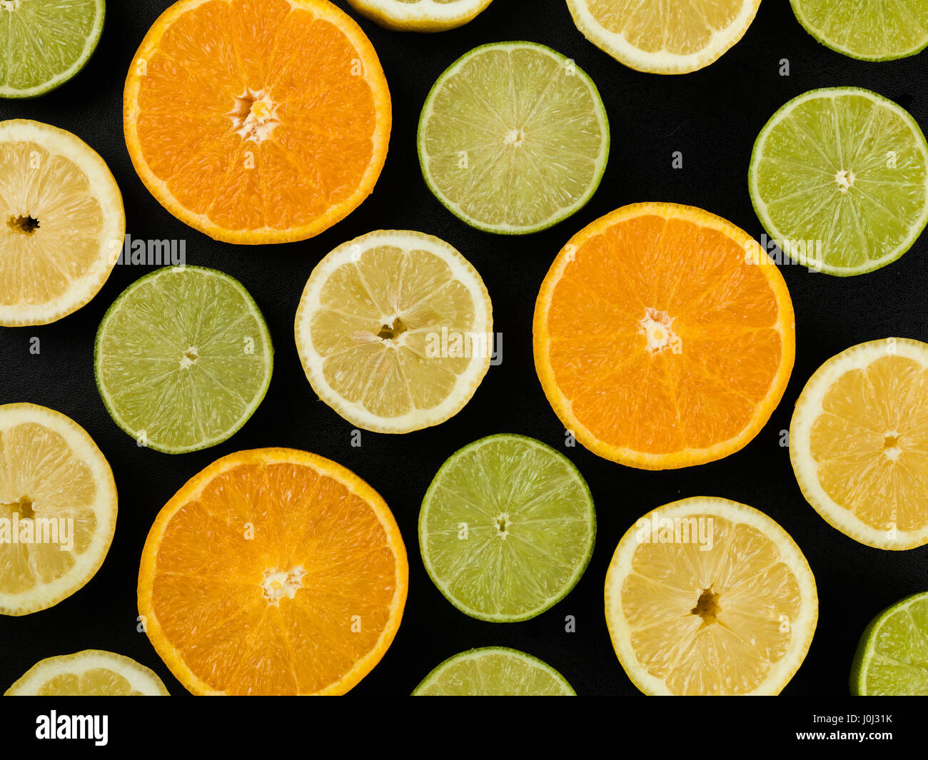 Orangen-Zitronen und Fresh Lime Zitrusfrucht vor schwarzem Hintergrund Stockfoto