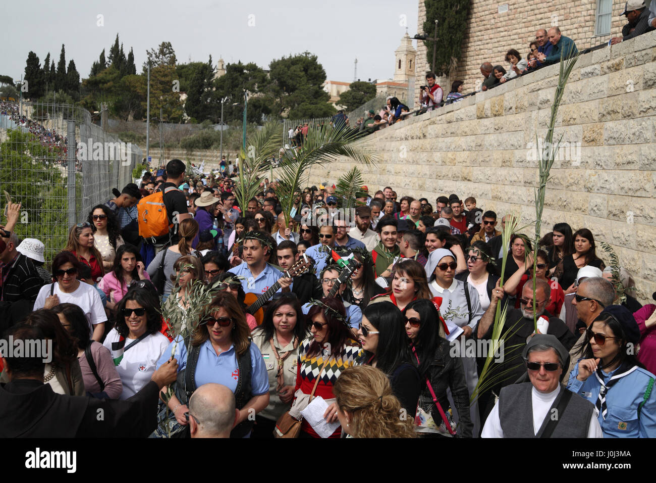 Christliche Pilger zu Fuß nach unten vom Ölberg in Prozession am Palmsonntag mit Oliven- und Palme Niederlassungen, einige singen und einige beten beginnen. Stockfoto