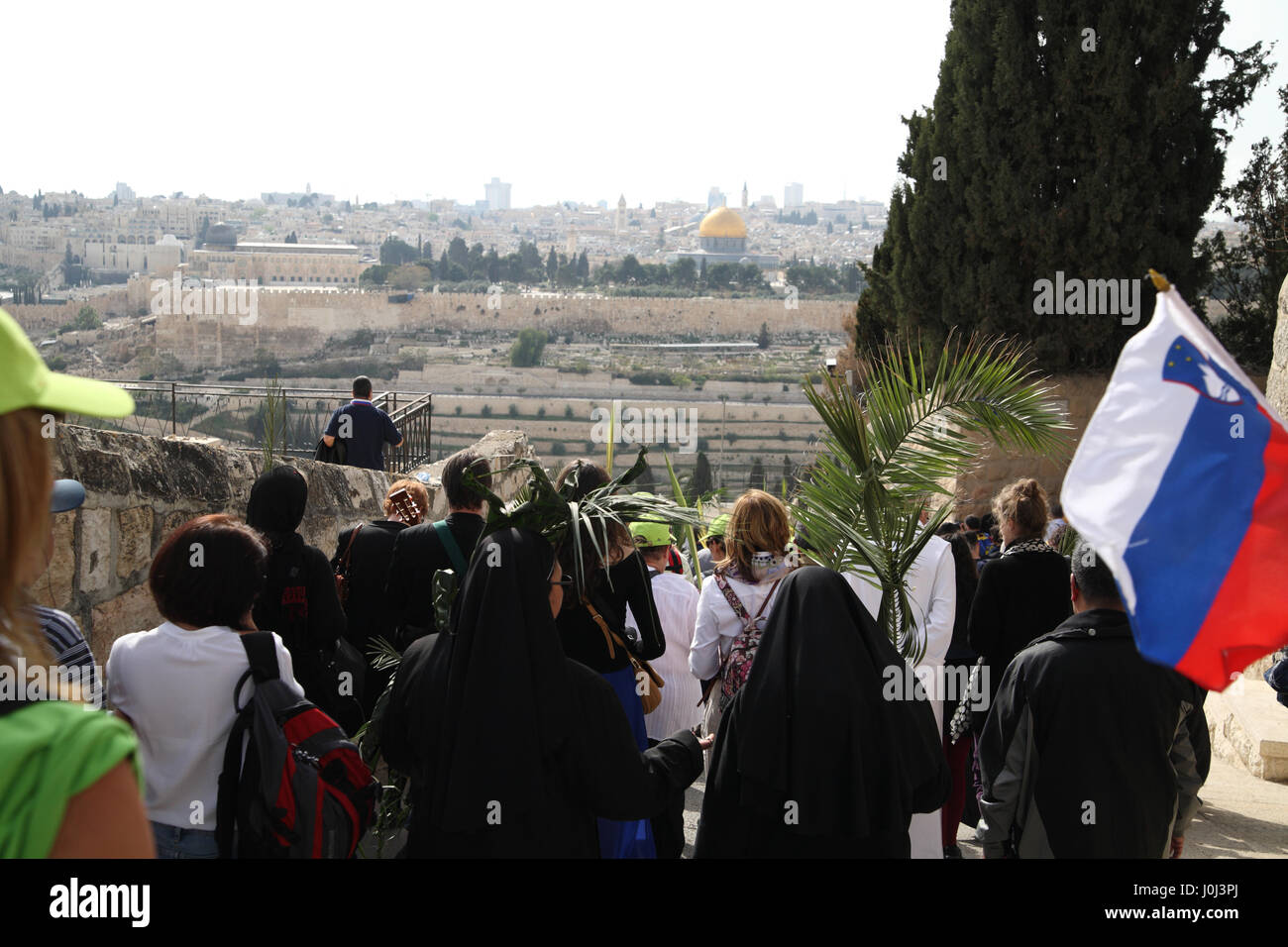Christliche Pilger Fuß in einer Prozession am Palmsonntag am Ölberg mit Palme Niederlassungen der Felsendom auf dem Tempelberg voraus zu sehen. Stockfoto
