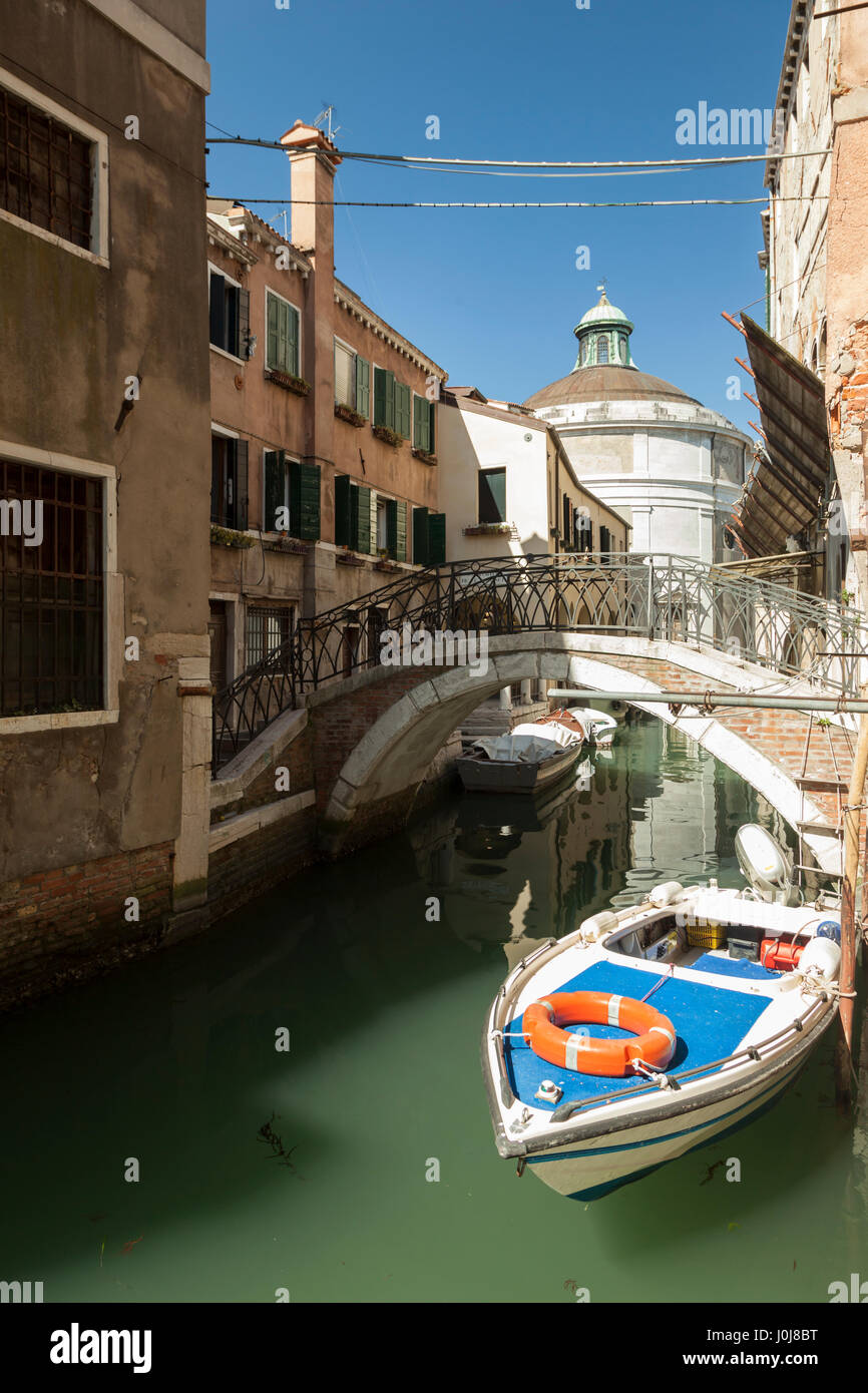 Frühlingstag auf einem Kanal in Sestiere Cannaregio, Venedig, Italien. Santa Maria Maddalena in der Ferne. Stockfoto