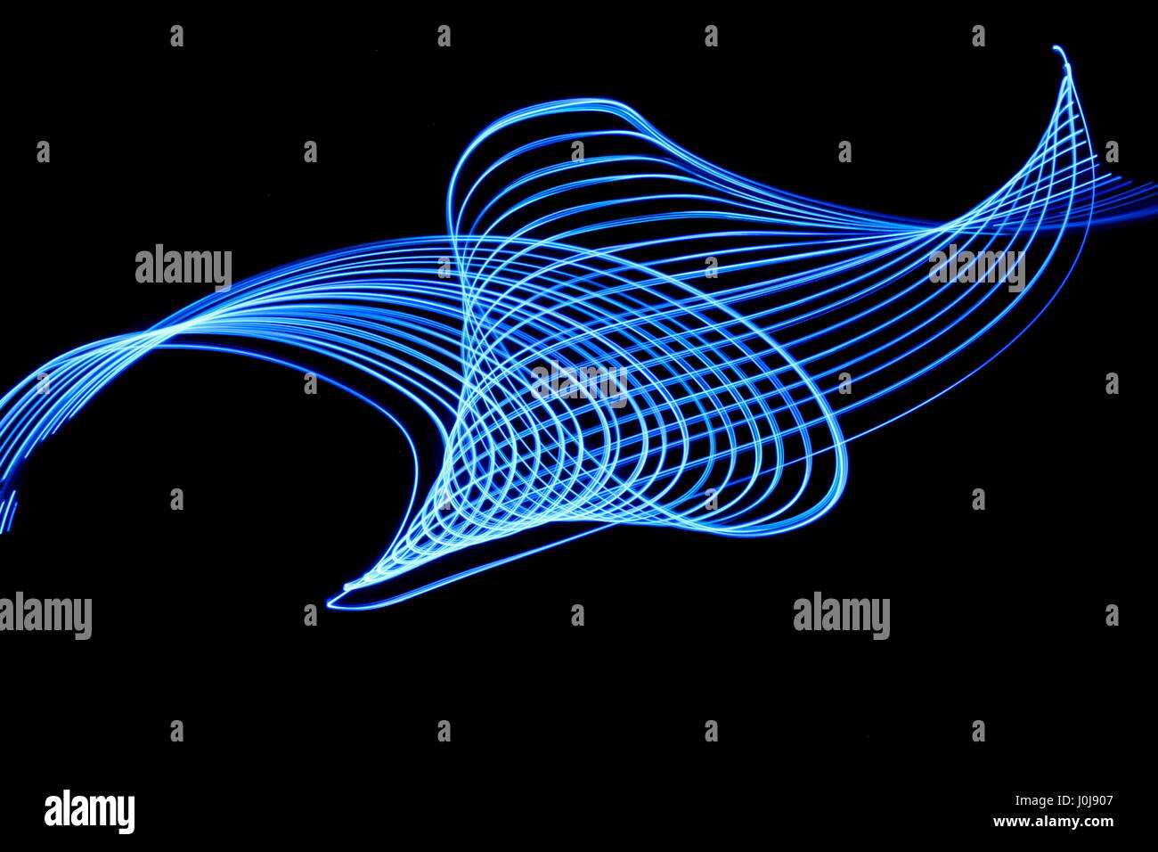 Blaues Licht Malerei Fotografie - parallele Linien in einen wirbelnden Muster vor einem schwarzen Hintergrund. Lange Belichtung Foto von abstrakten blaue Farbe. Stockfoto