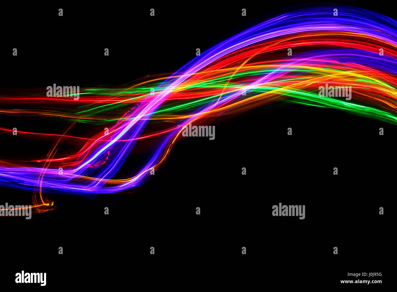 Mehrfarbige Licht Malerei Fotografie - Bewegung und Bewegung auf einem schwarzen Hintergrund. Lange Belichtung Foto von Neon Farbe in ein abstraktes Muster Stockfoto