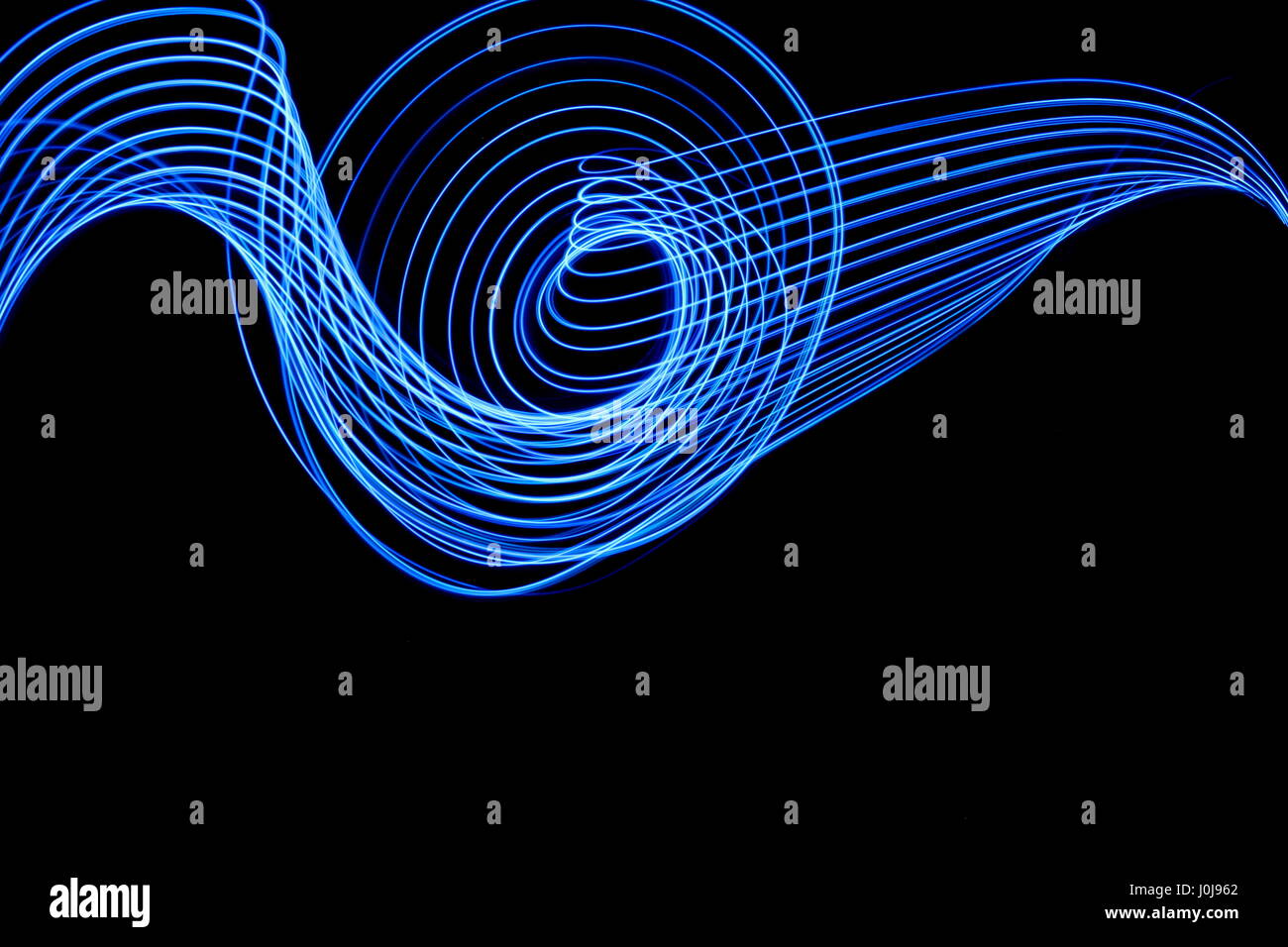 Blaues Licht Malerei Fotografie, blau parallele Linien wirbeln und Schleife Muster. Lange Belichtung Foto von Neon blaue Farbe in ein abstraktes Muster Stockfoto
