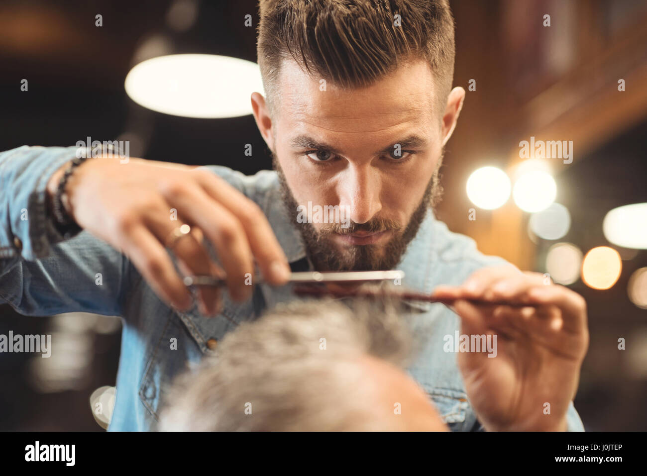 Aufmerksamen jungen Barbier im Frisörsalon Stockfoto