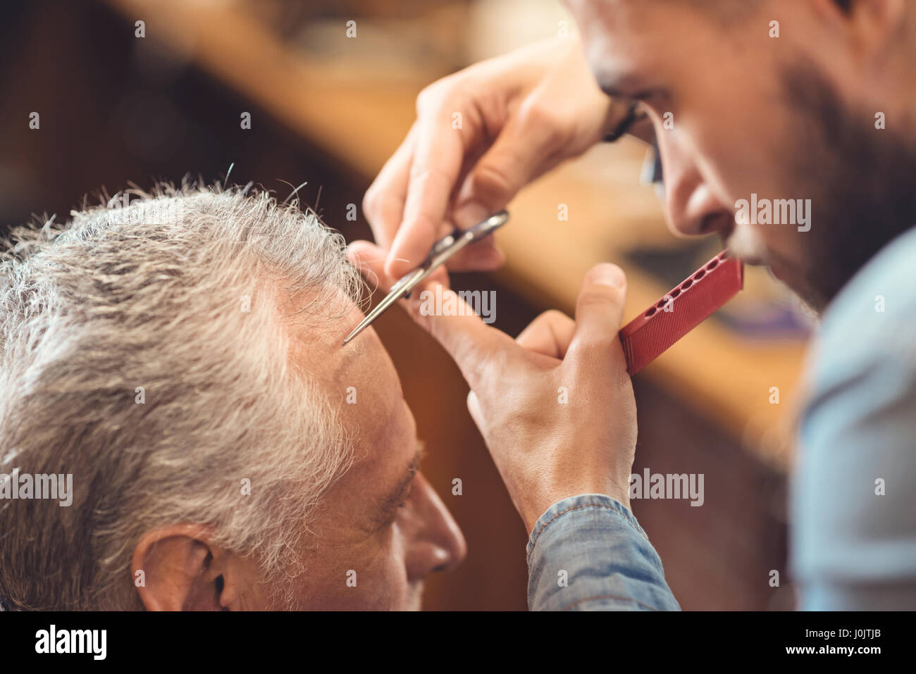 Meisterhafte Friseur die Frisur des pensionierten Kunden in barbershop Stockfoto