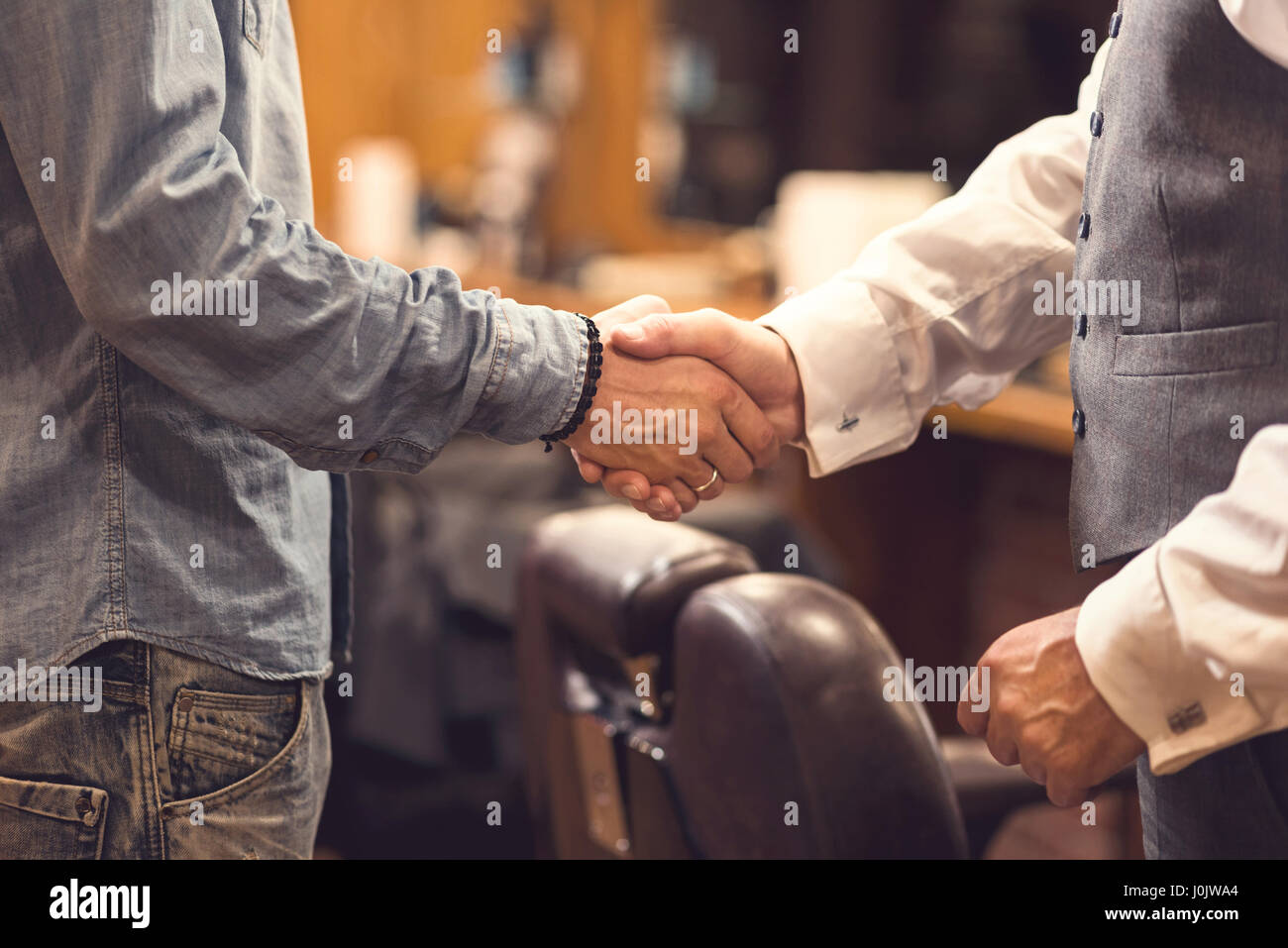 Im Alter von Client-Handshake mit Barbier im Frisörsalon Stockfoto