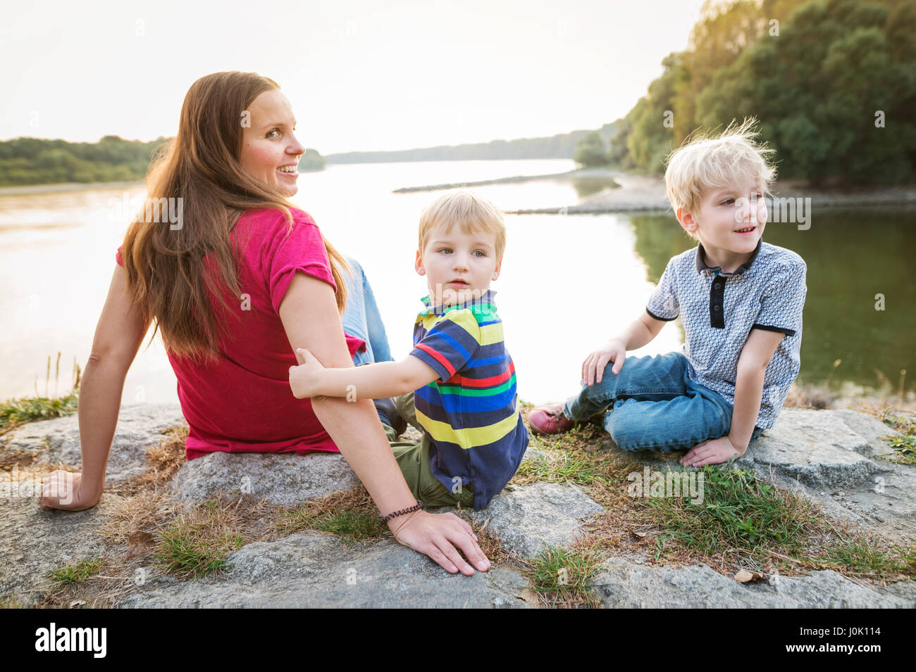 Mutter mit zwei Söhnen am See, sonnigen Frühlingstag. Stockfoto