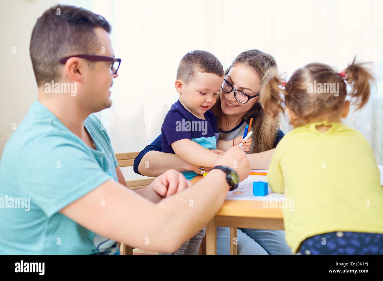 Mutter, Vater und Kinder ziehen zusammen auf dem Zimmer Stockfoto