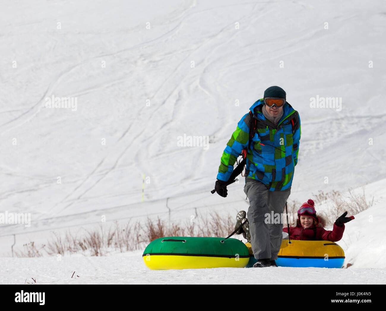 Vater und Tochter mit Snow-Tube am Sonnetag. Kaukasus, Georgien. Skigebiet Gudauri. Stockfoto