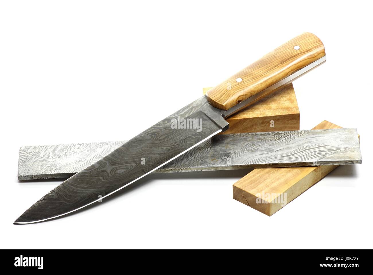 Handmade Damaskus Küchenmesser mit Rohstoffen isoliert auf weißem Hintergrund Stockfoto