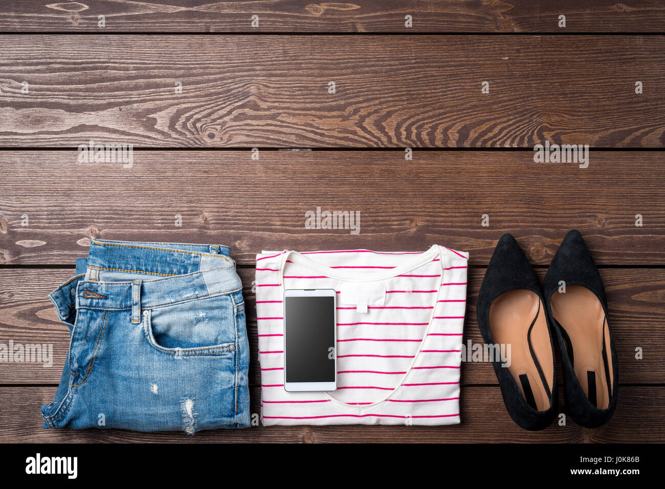 Weibliche Kleidung auf Holztisch Stockfoto