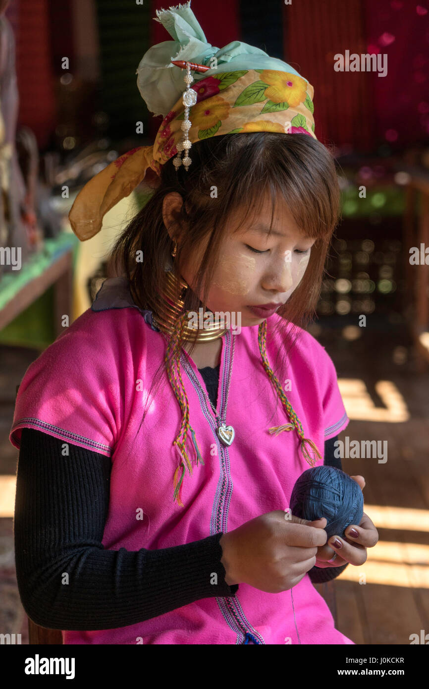 Junges Mädchen aus der Kayan Stamm hilft älteren Menschen mit Gewinde für ihre handgewebte Kleidung am Inle-See, Shan-Staat, Myanmar Stockfoto