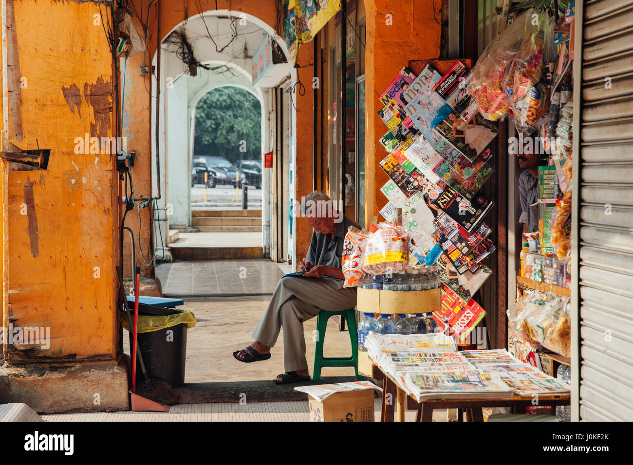 Kuala Lumpur, Malaysia - 17. März 2016: Verkäufer sitzt vor seinem Geschäft in Chinatown, Kuala Lumpur, Malaysia am 17. März 2016. Stockfoto