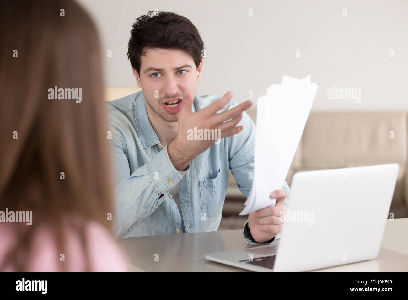 Verärgerter Mann schreien an Frau zeigt auf Dokumente in der hand Stockfoto