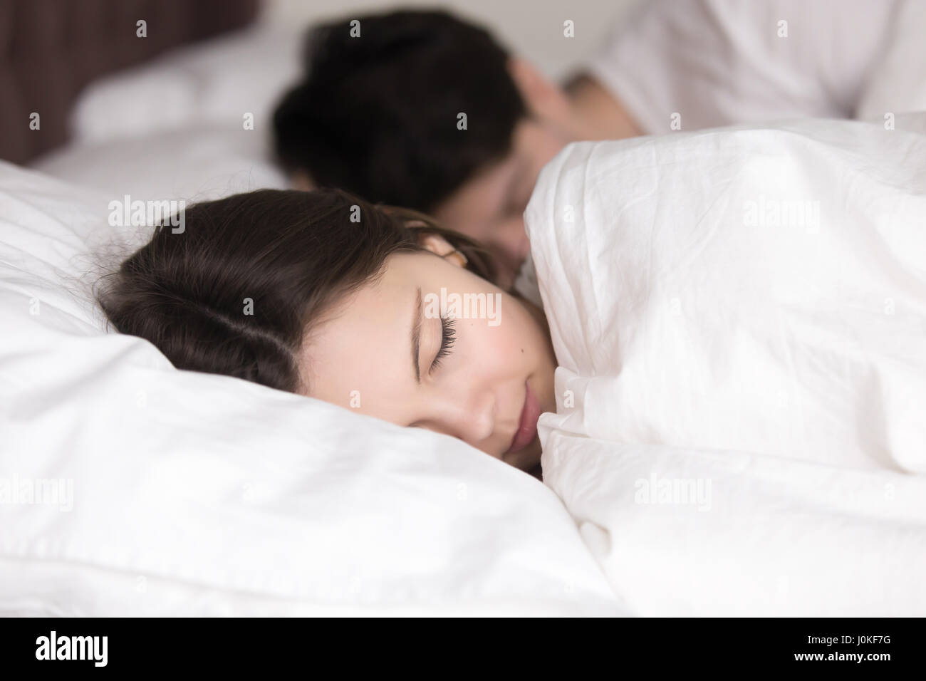Junges Mädchen mit Freund friedlich schlafend in kuscheligen weißen Bett Stockfoto
