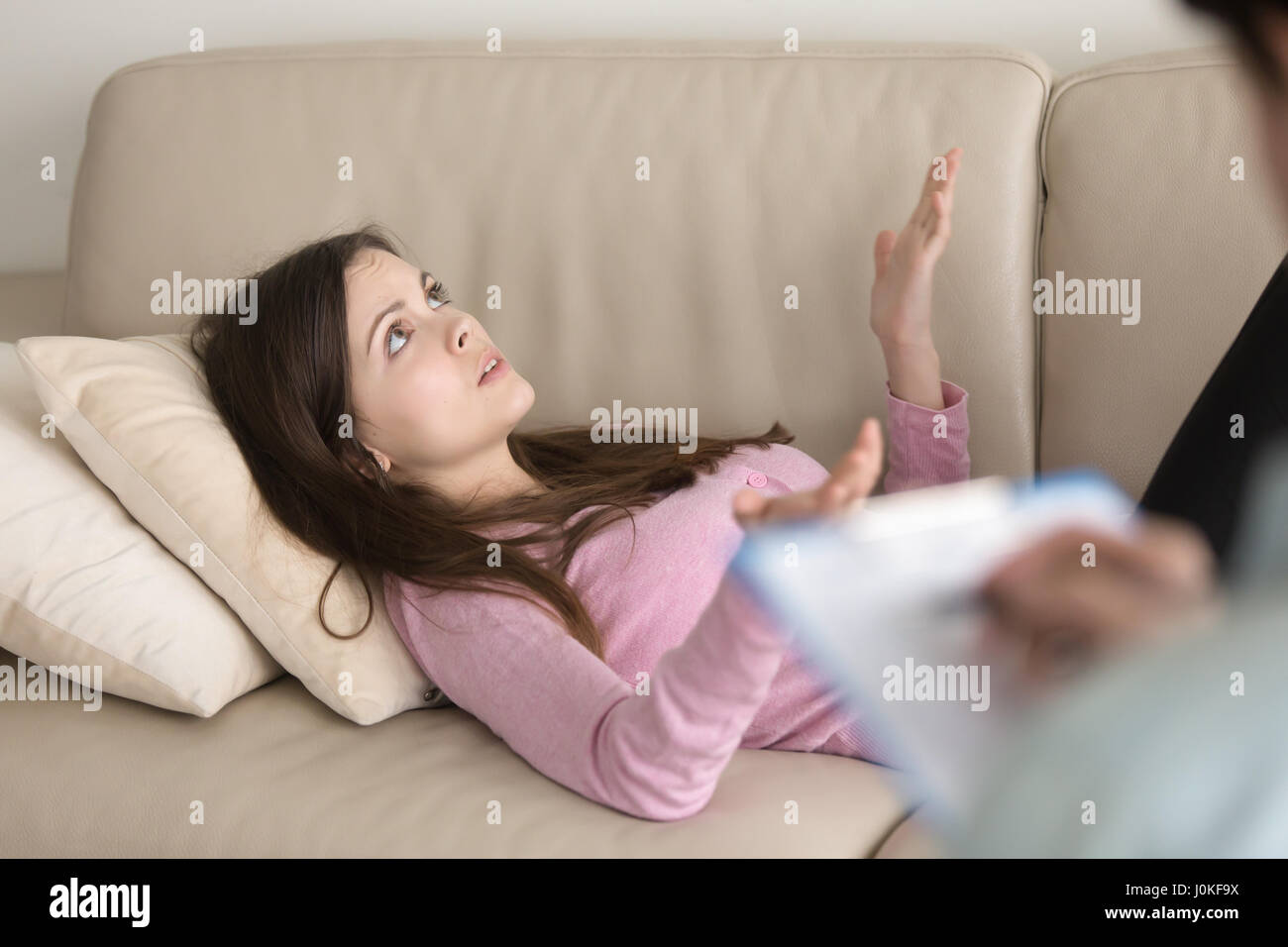 Junge Frau liegt auf couch und sprechen, zu Psychologen besuchen Stockfoto