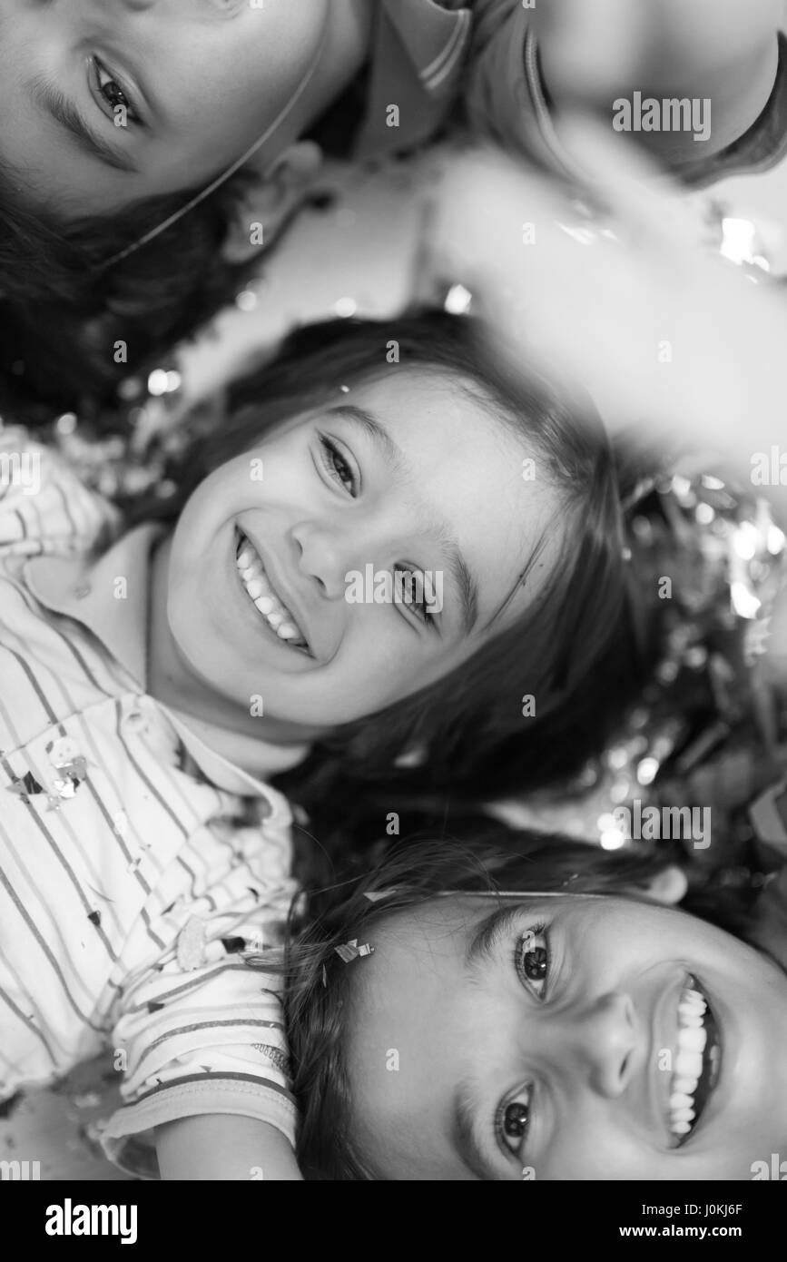 Glückliche Kinder feiern Party mit Konfetti auf dem Boden liegend Stockfoto