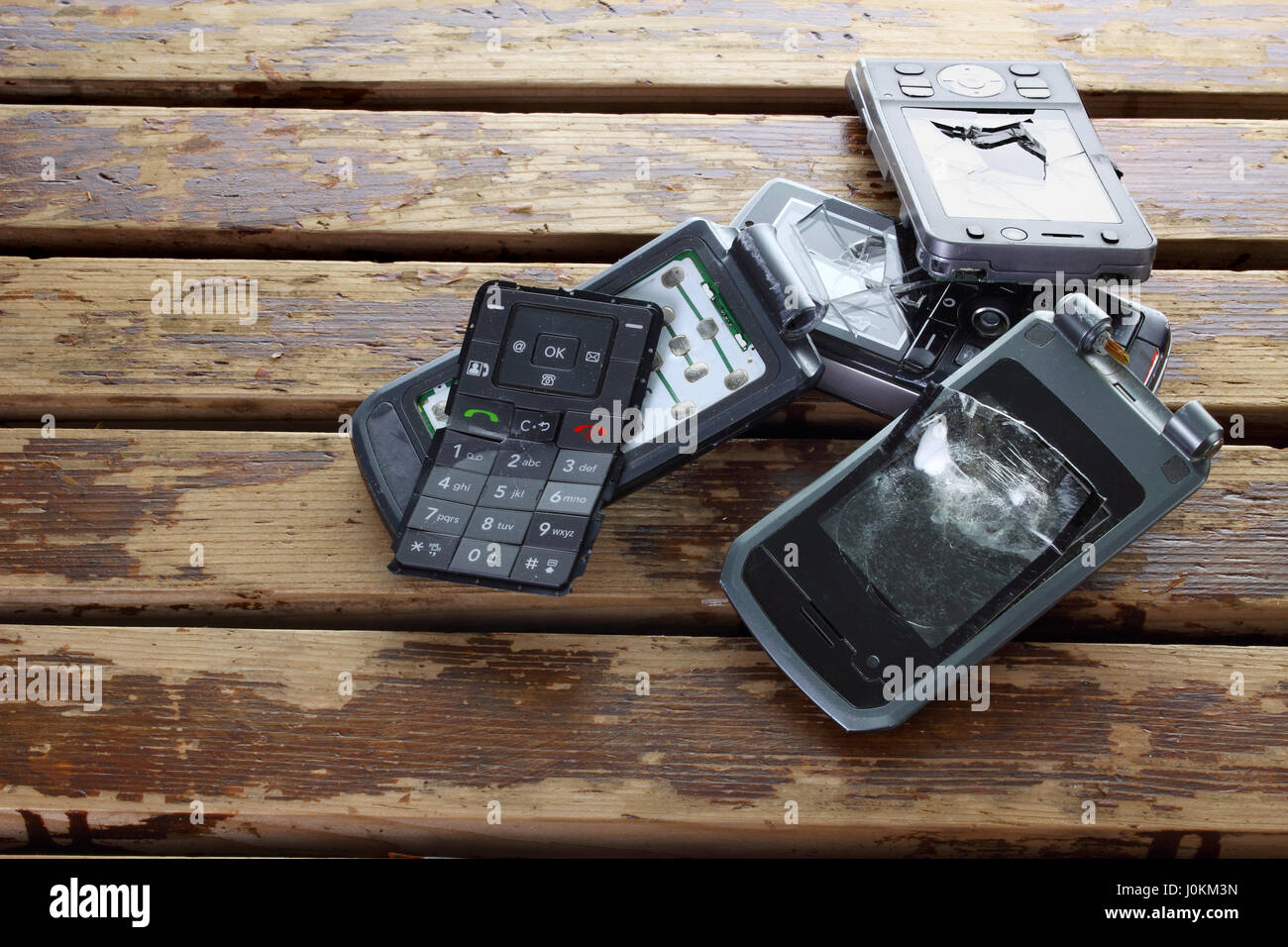 Defekte Handys auf hölzernen Hintergrund Stockfoto