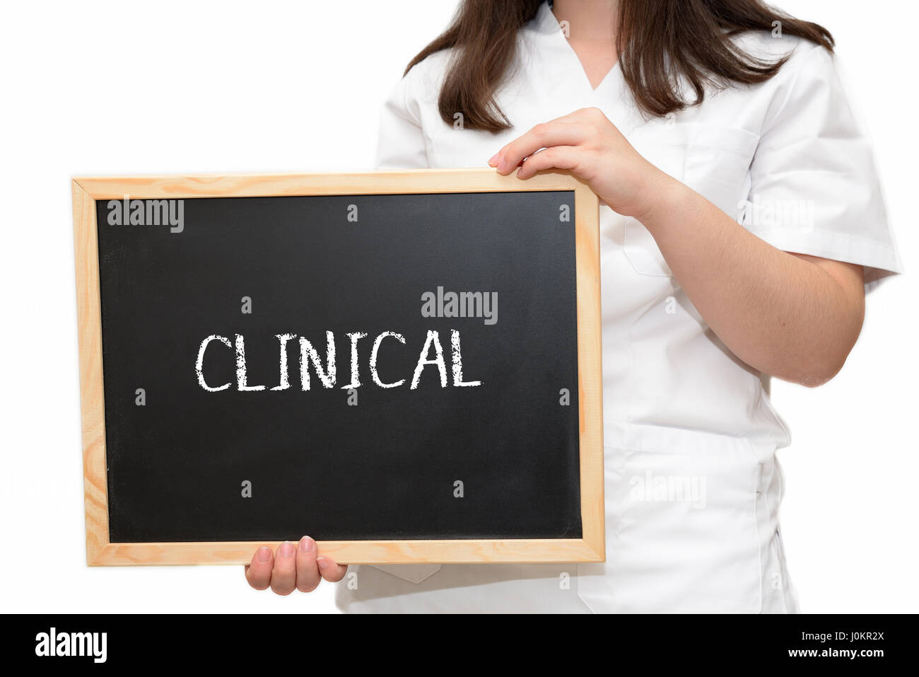 Krankenschwester hält ein Schiefer Board mit dem Text klinische mit Kreide, isoliert auf weißem Hintergrund geschrieben. Stockfoto