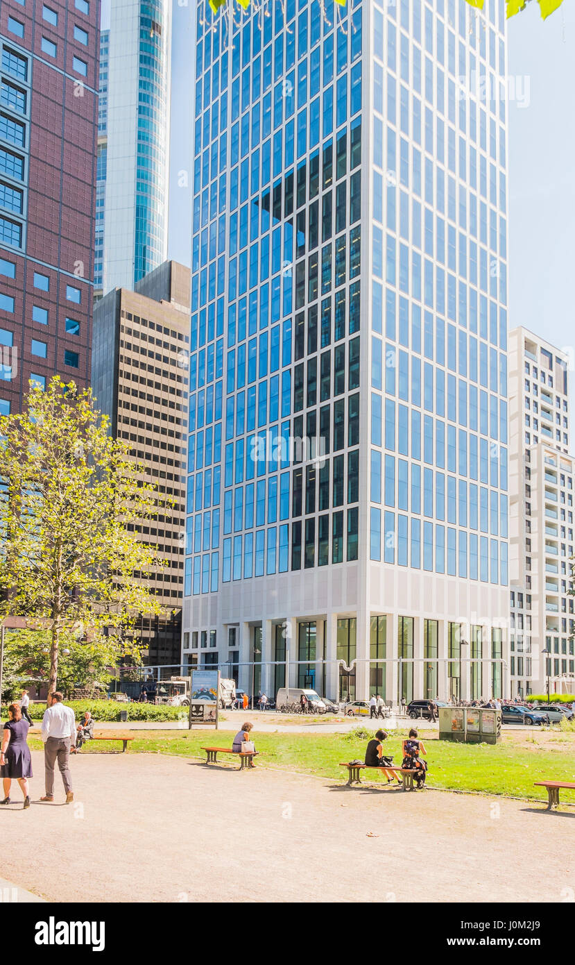 Mitarbeiter, die ein Mittagessen brechen im öffentlichen Park Taunusanlage mit Bürogebäude im Hintergrund Stockfoto