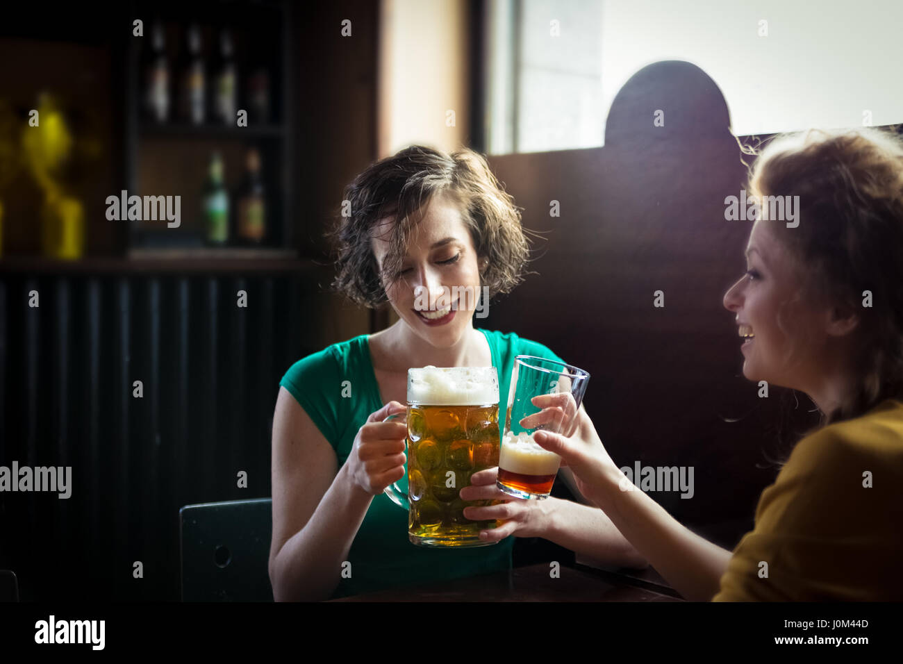 Brünette Frau bei einem Glas Bier Stockfoto