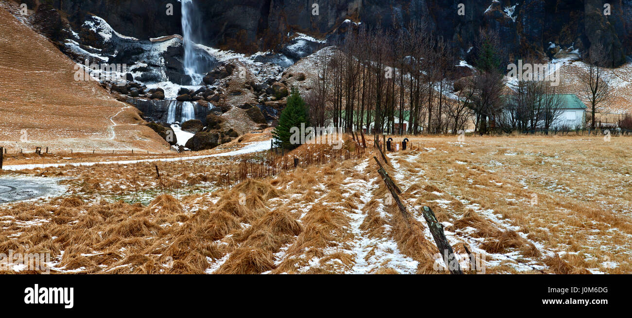 Haus am Wasserfall: isländische Berge und Landschaft Wasserfall Stockfoto