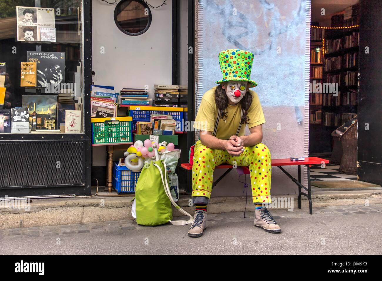 Zagreb, Kroatien - Clown sitzt vor einem antiken Buchladen Stockfoto