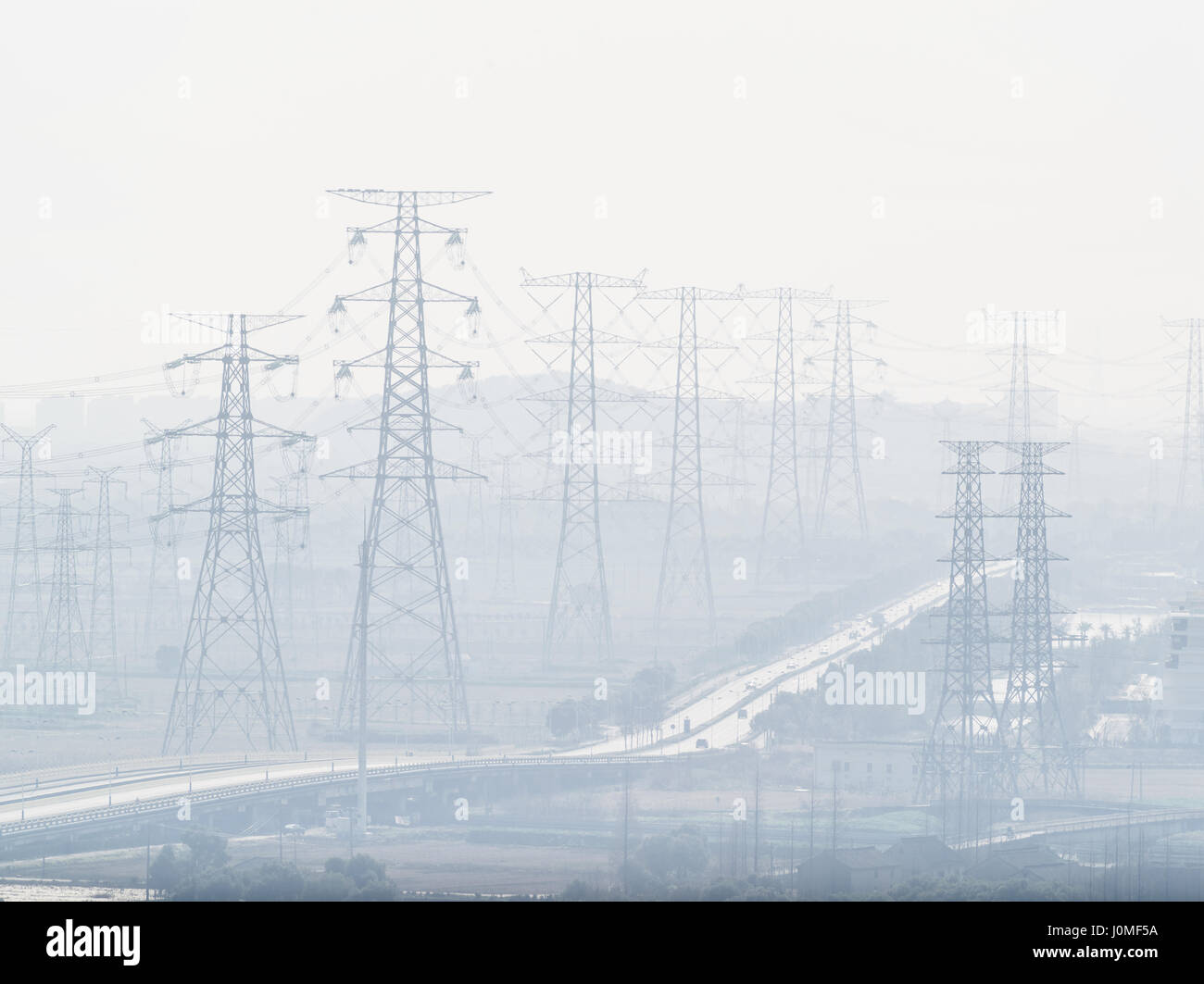 Pylon und Stromleitungen in stark verschmutzter Luft. Stockfoto