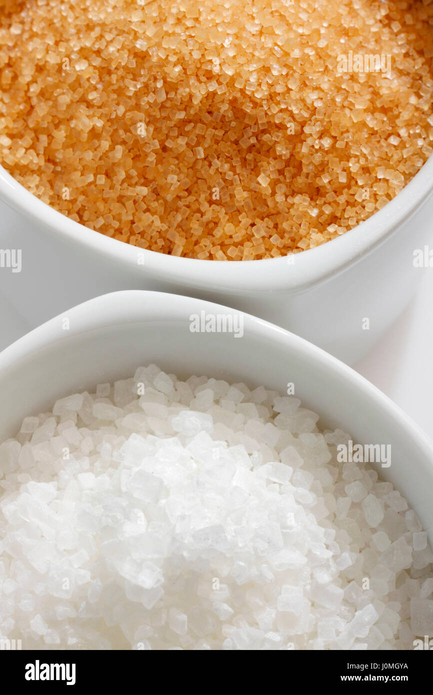 Braunen und weißen Zuckerkristalle in Gerichten. Draufsicht. Stockfoto