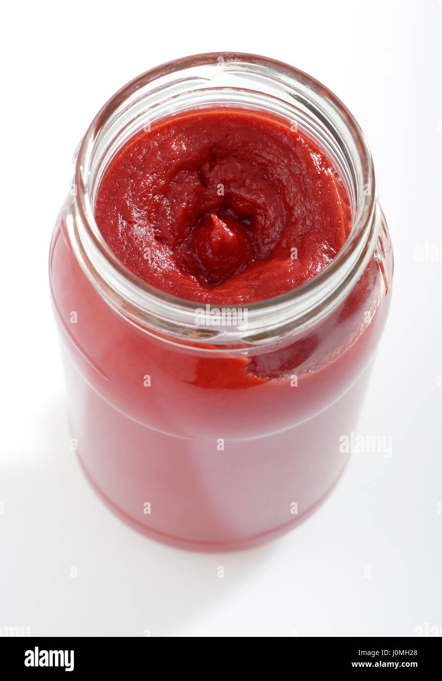 Geöffnete Dose mit Tomatenmark. Ansicht von oben auf hellem Hintergrund. Stockfoto