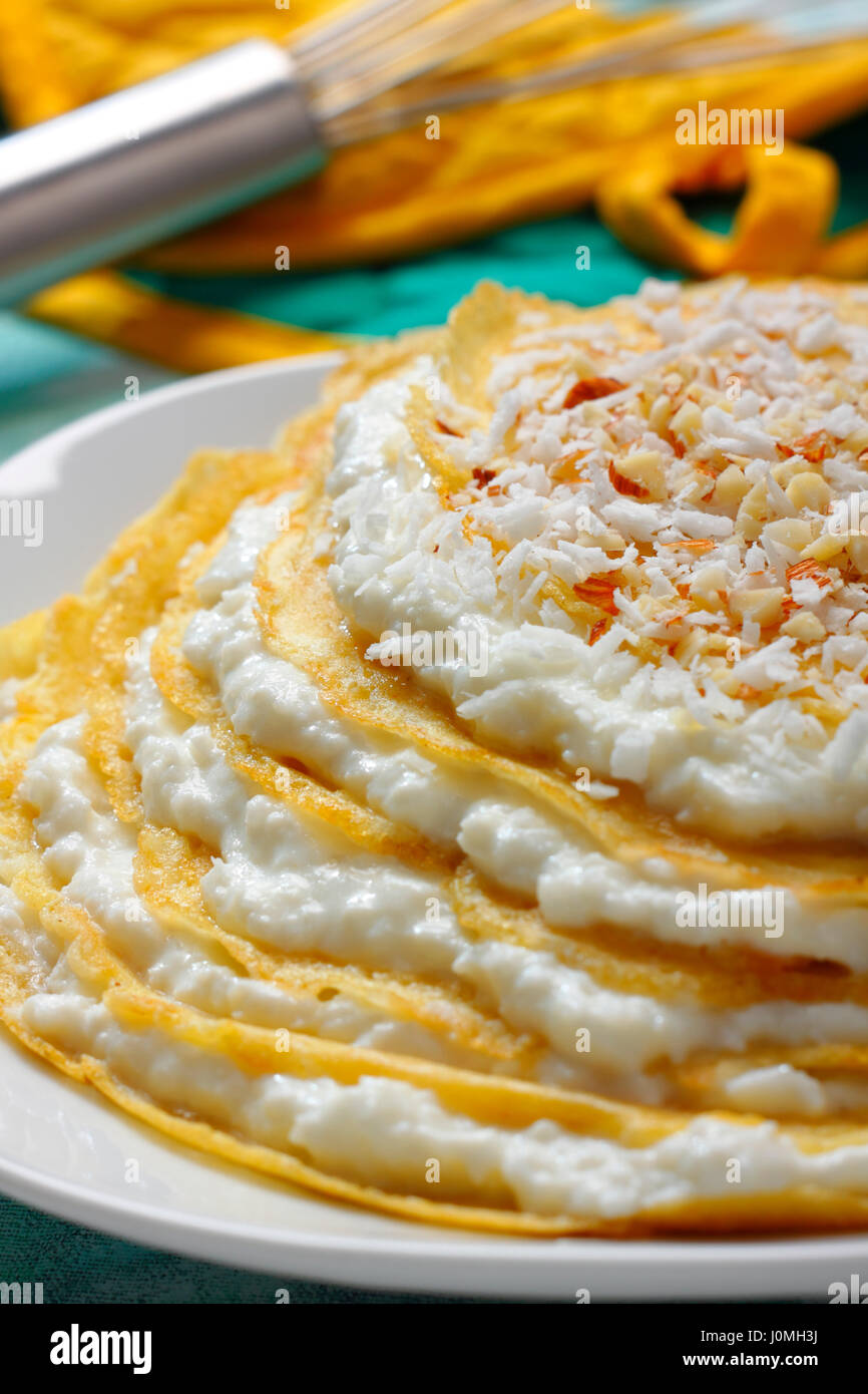 Haufen von Crepes mit Frischkäse-Füllung und geriebene Kokosnuss-topping Stockfoto