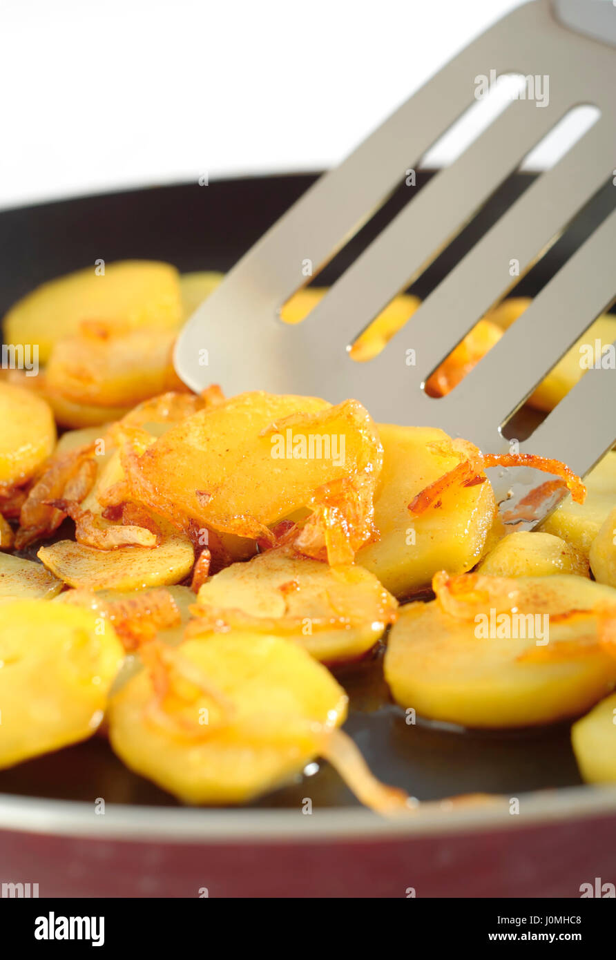 Die Nahaufnahme auf gebratenen Kartoffeln Scheiben mit Zusatz von fein gehackte Zwiebel. Stockfoto