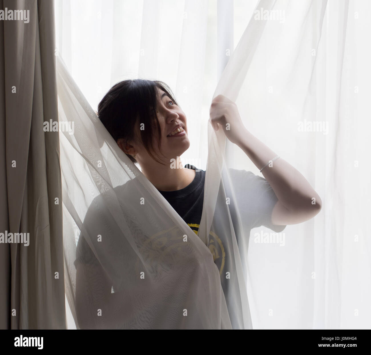Chinesische Mädchen steht vor Fenster Stockfoto