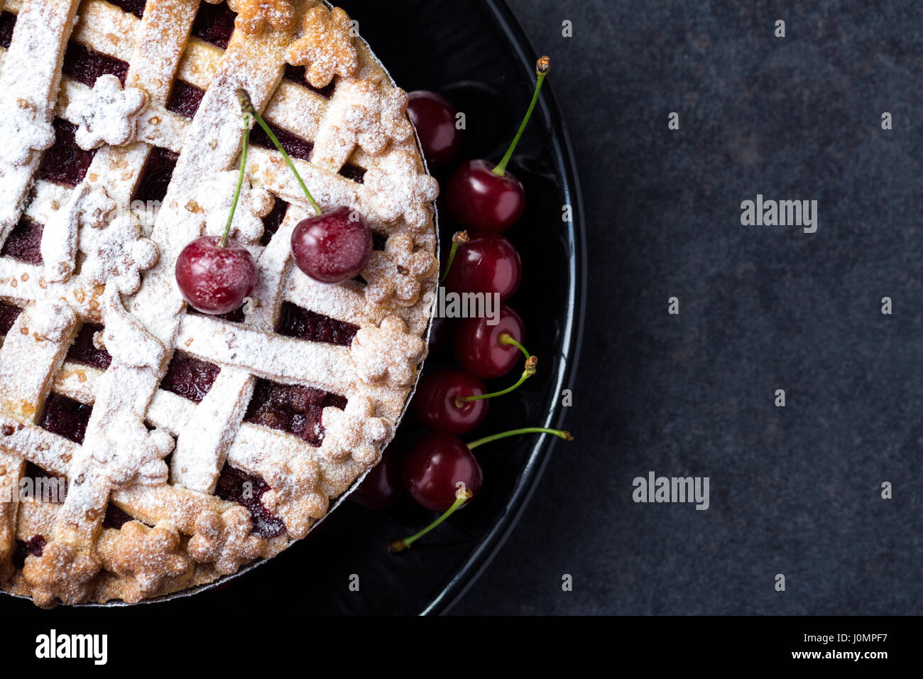 Amerikanische Torte mit Kirschen, Puderzucker auf der schwarzen Platte Stockfoto