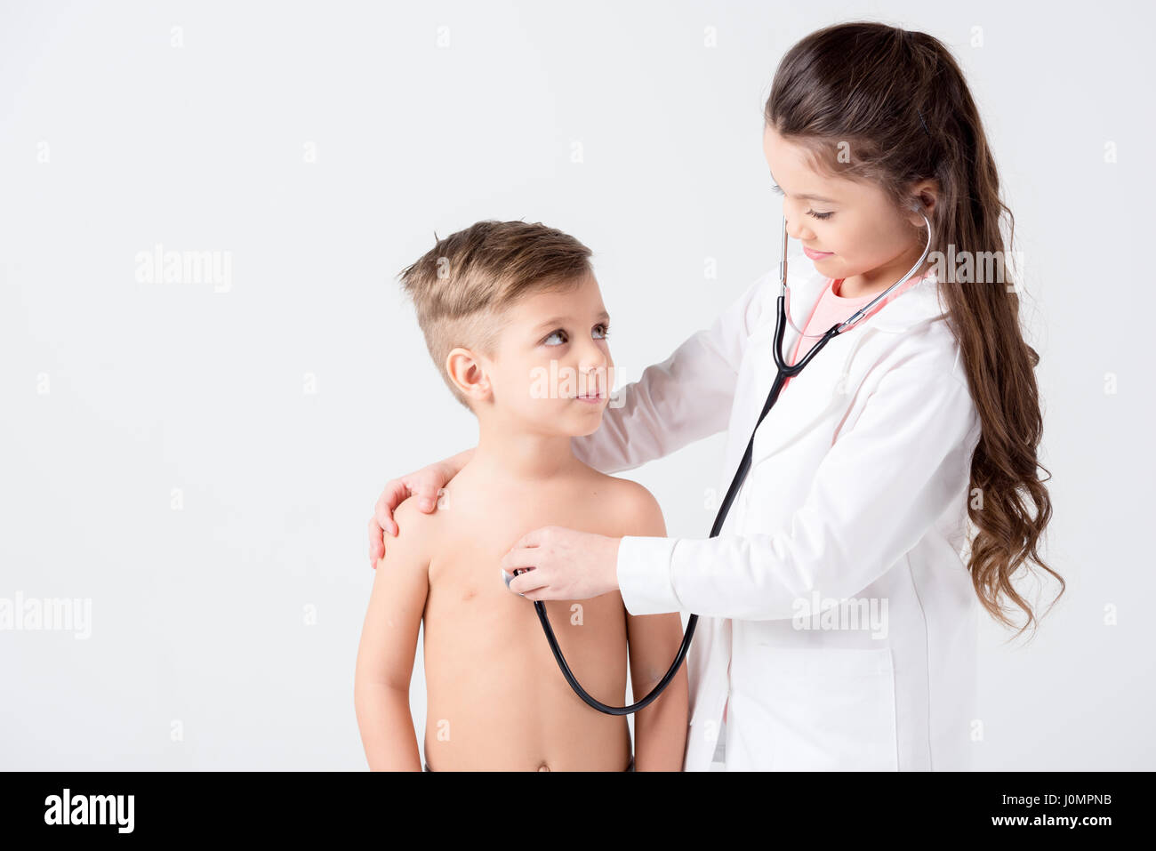 Niedliche kleine Jungen und Mädchen spielen Arzt und Patient mit Stethoskop Stockfoto