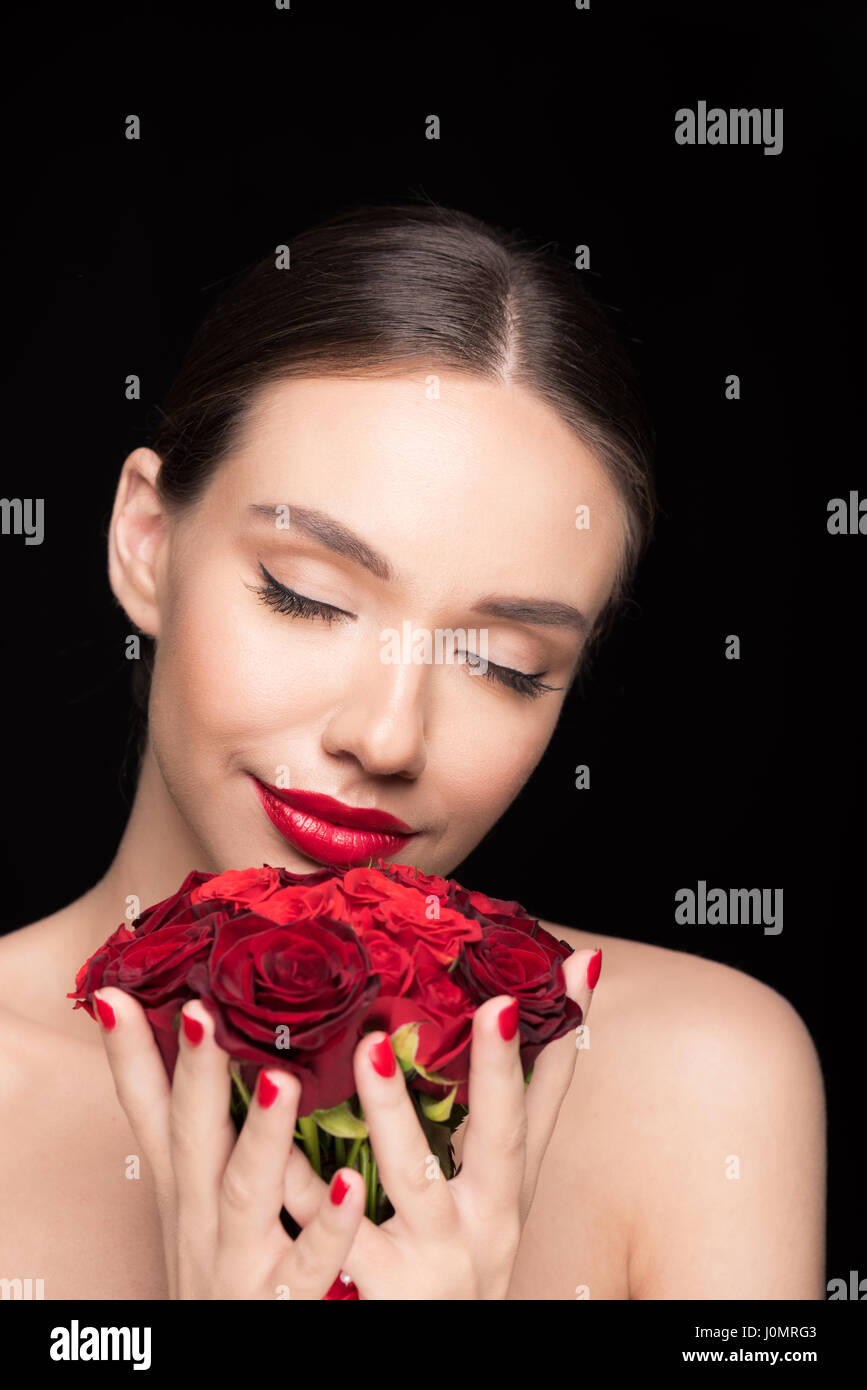 schöne Frau mit geschlossenen Augen halten Rosen Stockfoto