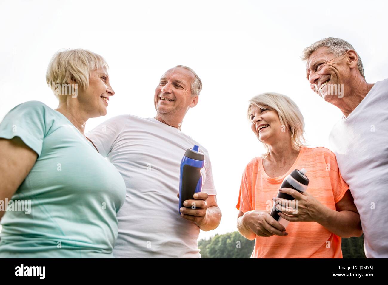 Vier Leute draußen mit Wasserflaschen. Stockfoto