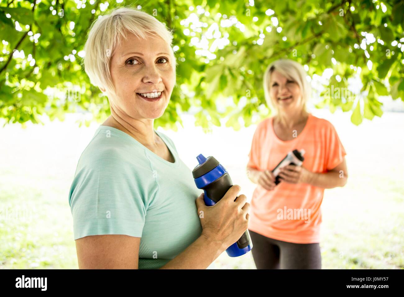 Zwei Frauen halten Sport Flaschen. Stockfoto