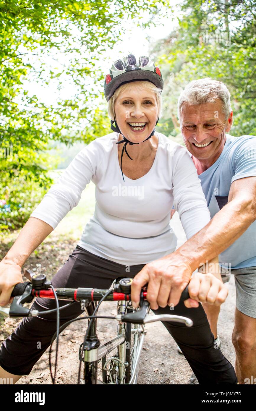 Reife Frau auf Fahrrad, älterer Menschen unterstützen. Stockfoto
